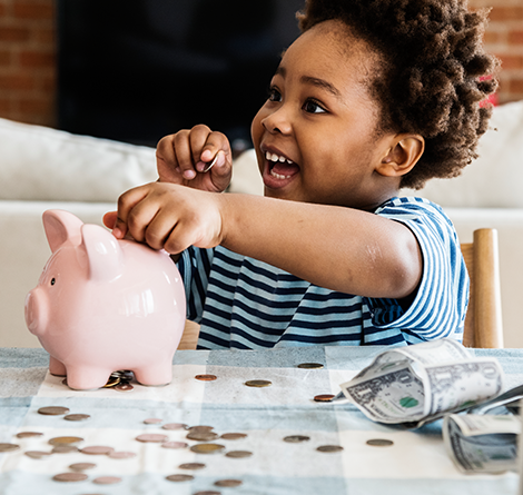 An adorable child counting her money in her piggy bank