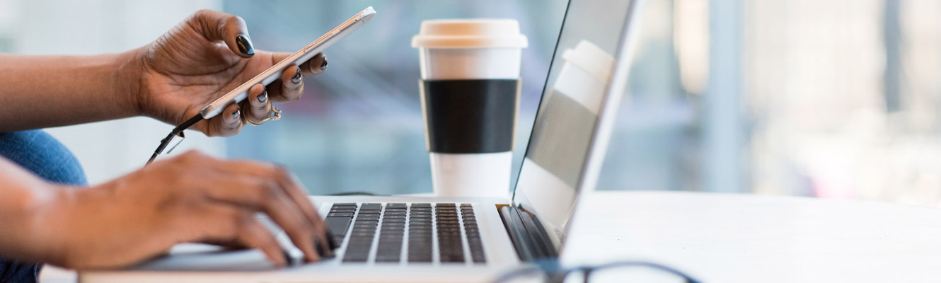 A woman working on a laptop with coffee