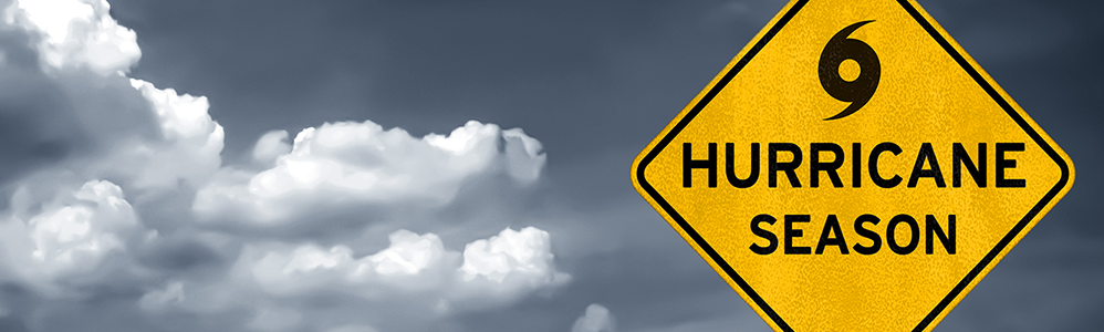 A hurricane season sign with clouds in the background.
